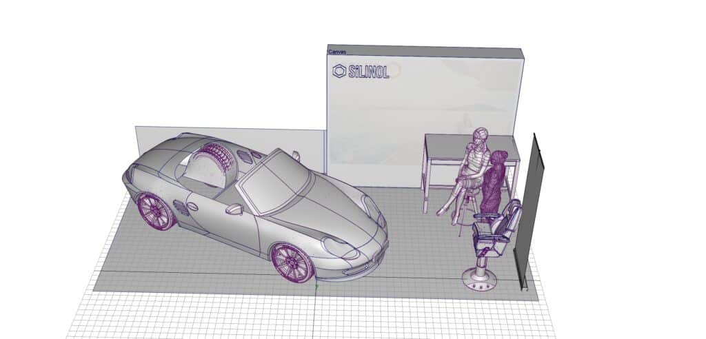 3D wireframe render of a 10 by 20 trade show booth layout with a Porsche model, a Silinol branded backdrop, a consultation desk, and a marine chair display.
